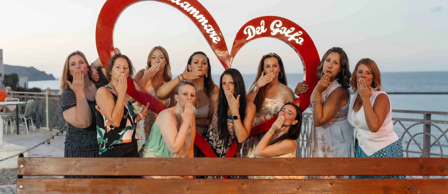 The retreat group laughing behind the red Castellammare del Golfo heart sculpture