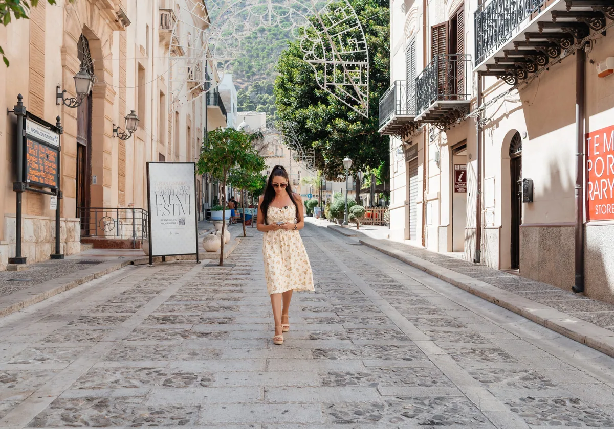 Carla walking a quiet stepped street in Castellammare del Golfo