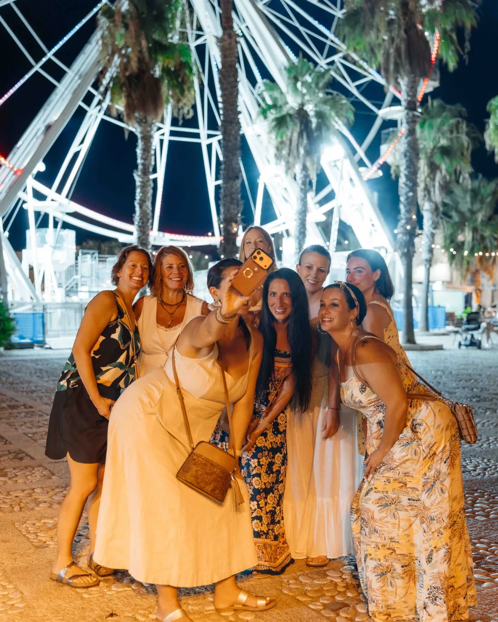 The retreat group together under the lit seafront ferris wheel at night