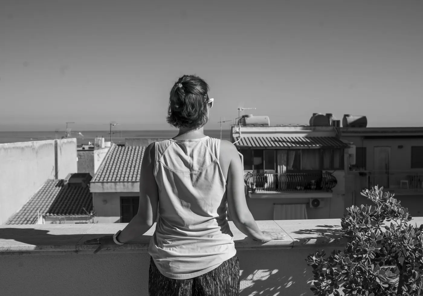 A guest looking out over the rooftops of Castellammare del Golfo in black and white