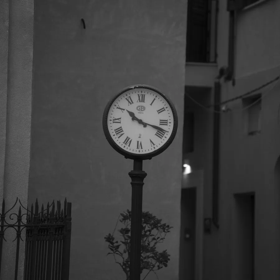 A street clock in a narrow Castellammare alley, black and white