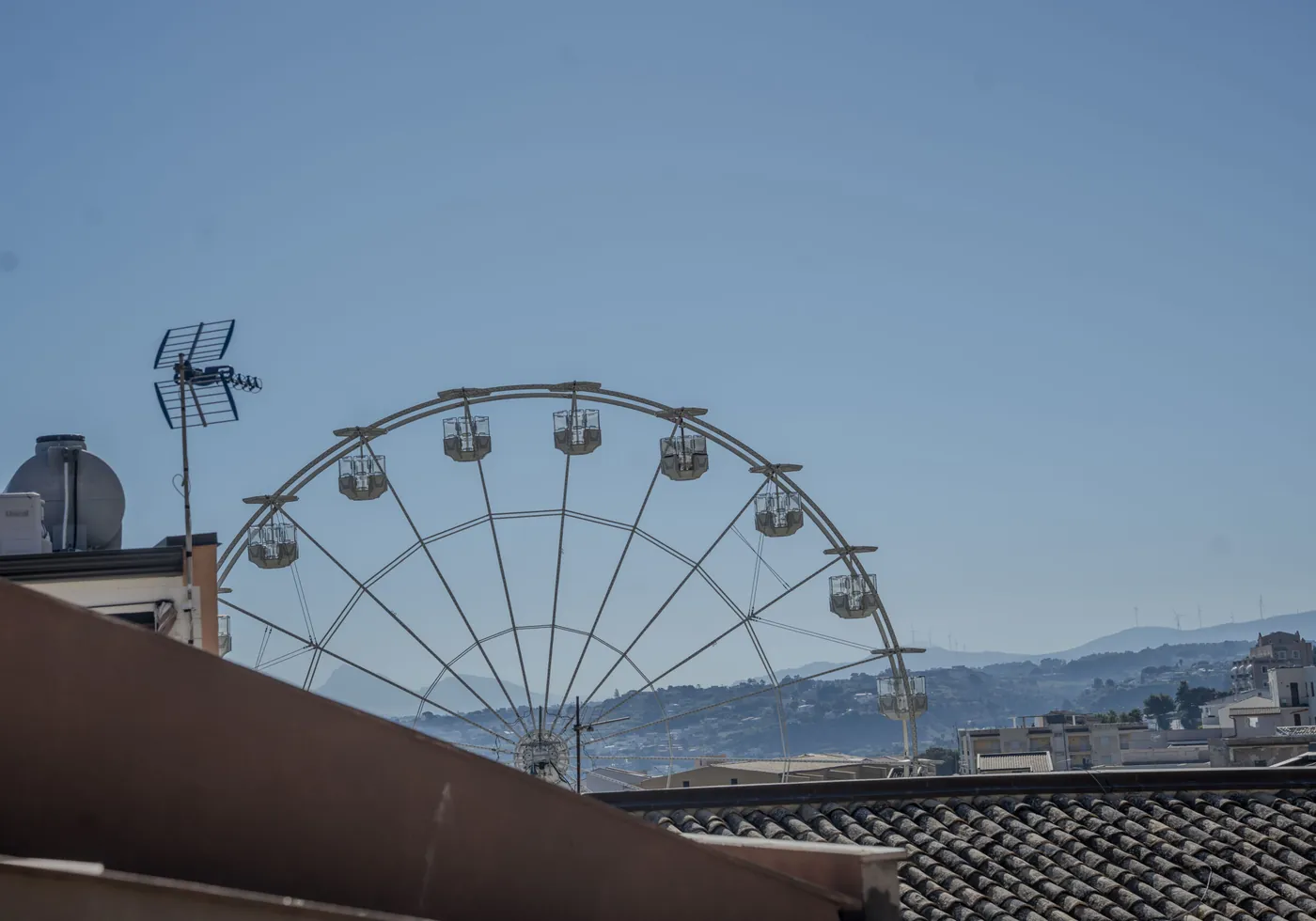Rooftops of Castellammare del Golfo with the seafront ferris wheel and hills beyond