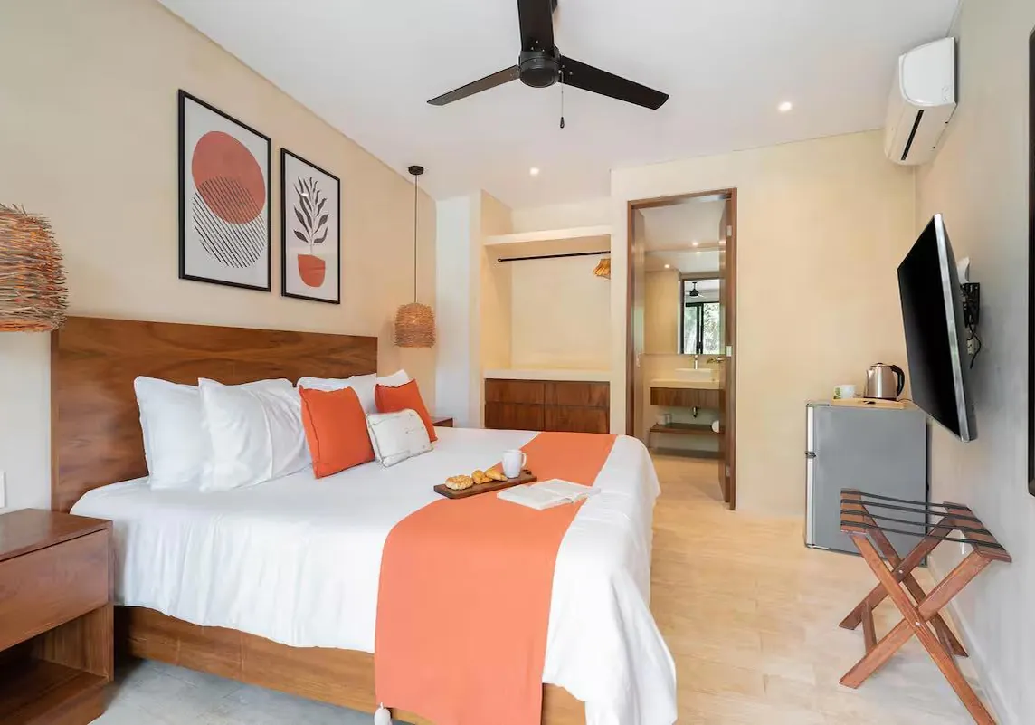 A Jungle Studio with a king bed, coral accents and a mini fridge