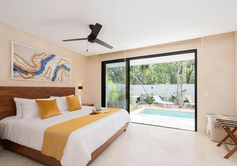 A suite bedroom with a king bed opening onto a private plunge pool